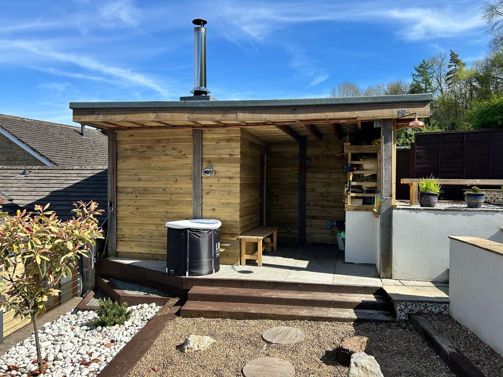 Finished timber garden sauna cabin with covered deck and cold plunge tub