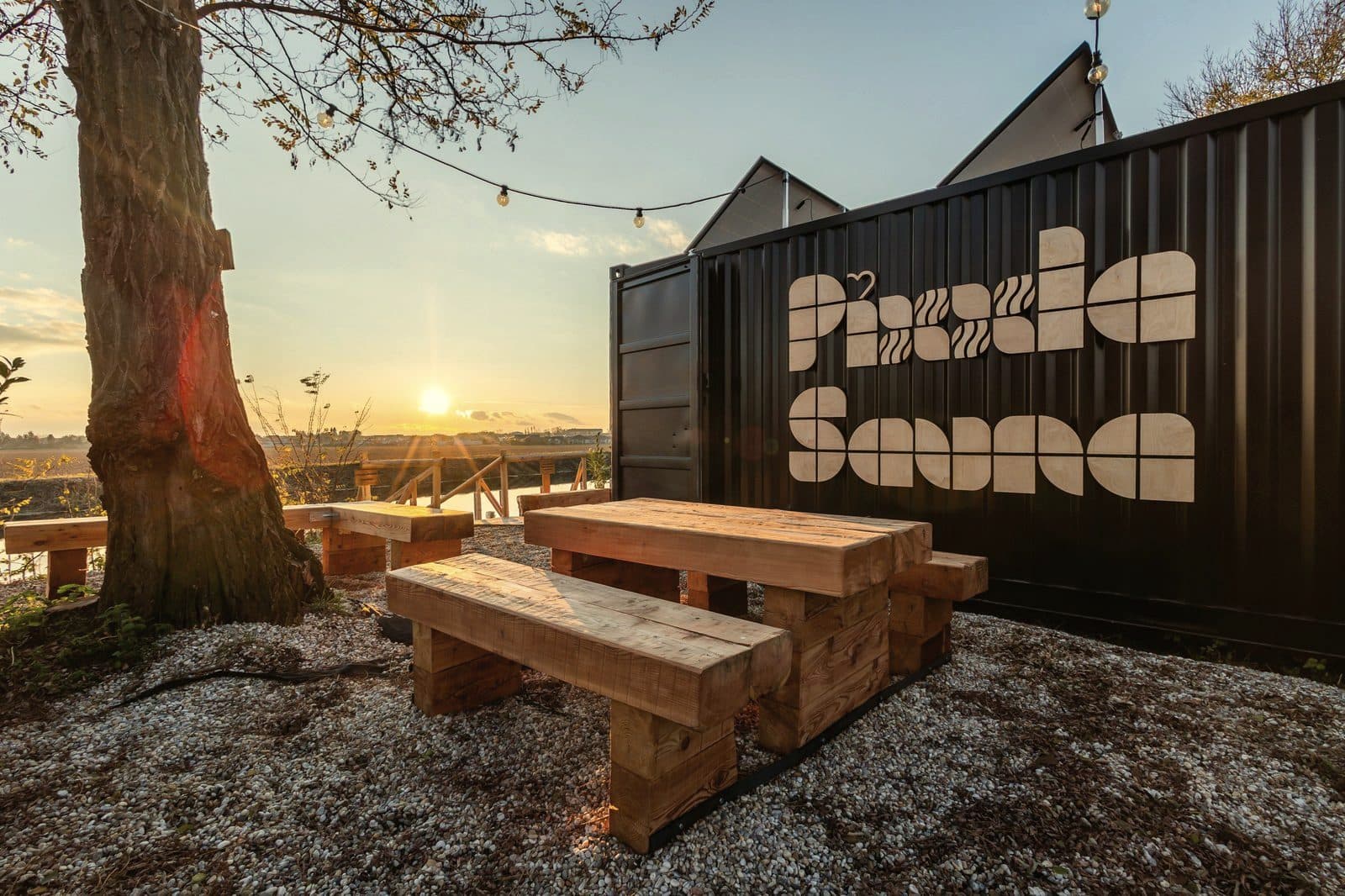 Container sauna with outdoor seating area at sunset