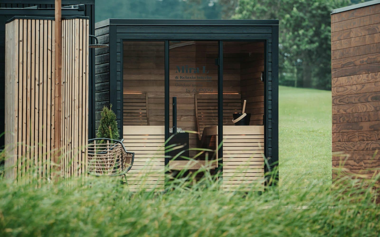 Modern outdoor sauna cabin in a garden setting with timber cladding